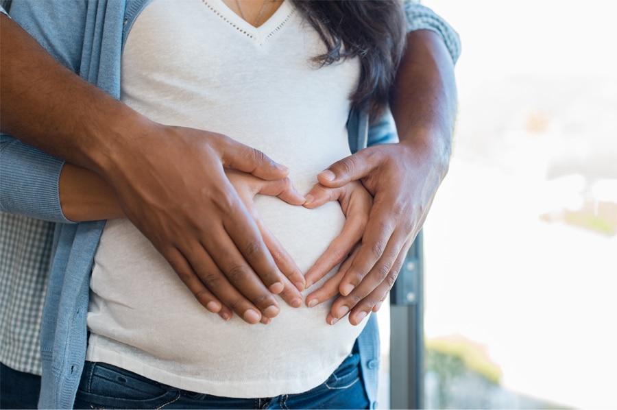 couple holding woman's pregnant belly