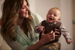 mom posing with smiling baby