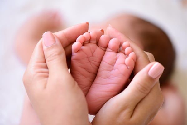 woman holding baby's feet